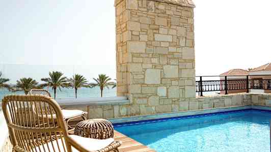 Terassi, jossa uima-allas, aurinkotuoleja ja näkymä merelle. (Tekoälyn luoma teksti)