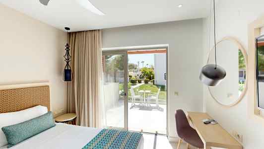 Makuuhuone, jossa sänky, kirjoituspöytä ja lasiovi terassille, jossa ulkokalusteet. (Tekoälyn luoma teksti)