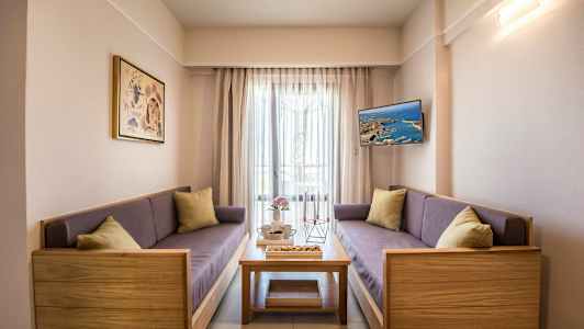 Olohuone, jossa on kaksi sohvaa, sohvapöytä ja seinälle kiinnitetty TV. (Tekoälyn luoma teksti)