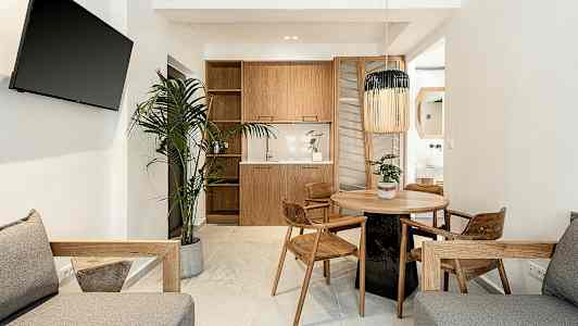 Moderni olohuone, jossa puisia kalusteita, pyöreä ruokailupöytä ja kasvi. (Tekoälyn luoma teksti)