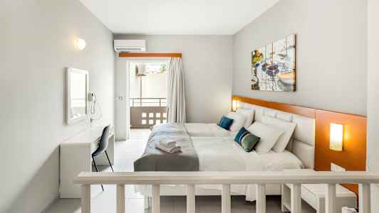 Huone, jossa on kaksi sänkyä, työpöytä ja parveke. (Tekoälyn luoma teksti)