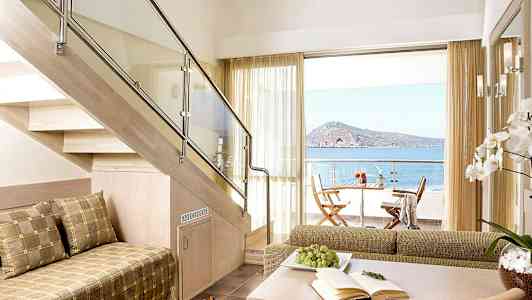 Nykyaikainen huone, jossa puuportaat, istuimia ja näkymä merelle terassilta. (Tekoälyn luoma teksti)