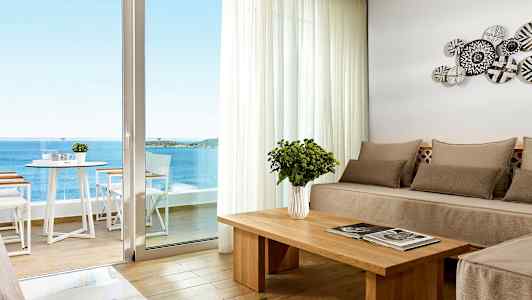 Modernisti sisustettu huone, josta on merinäköala suuren ikkunan kautta. (Tekoälyn luoma teksti)