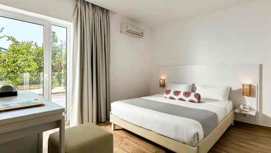 Makuuhuone, jossa on parisänky, yöpöytä ja kirjoituspöytä lähellä ikkunaa. (Tekoälyn luoma teksti)