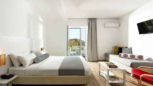 Moderni hotellihuone, jossa parivuode, sohva, pöytä ja parveke näköalalla. (Tekoälyn luoma teksti)