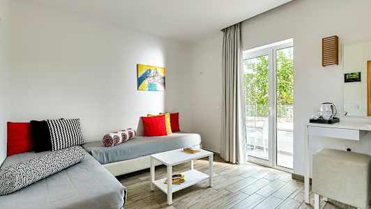 Huone, jossa istuinalue ja pöytä, sisustettu vaaleilla väreillä. (Tekoälyn luoma teksti)