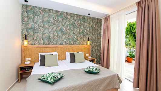 Makuuhuone, jossa on parivuode, vihreät tyynyt ja koristeltu seinä. (Tekoälyn luoma teksti)