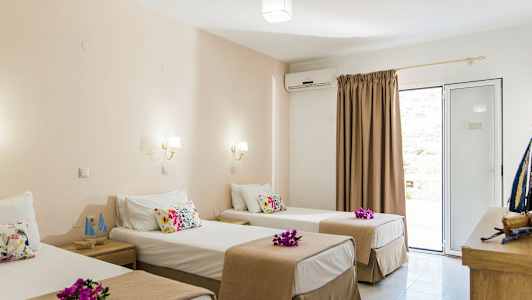 Hotellihuone, jossa on kolme yksittäistä vuodetta, koristettu kukilla. (Tekoälyn luoma teksti)