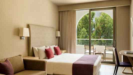 Hotellihuone, jossa parivuode, sohva ja parveke. (Tekoälyn luoma teksti)