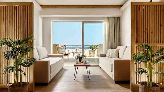 Moderni olohuone, jossa kaksi sohvaa ja näkymä terassille ja merelle. (Tekoälyn luoma teksti)