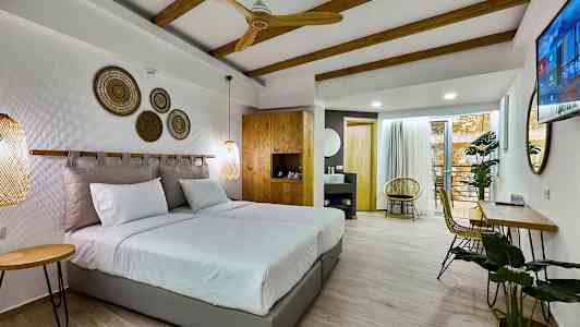 Moderni hotellihuone, jossa on parivuode, puupalkit ja istuinryhmä. (Tekoälyn luoma teksti)