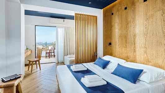 Valoisa hotellihuone, jossa on parivuode ja puuyksityiskohtia, näkymä parvekkeelle ja merelle. (Tekoälyn luoma teksti)