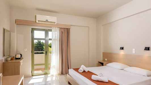 Hotellihuone, jossa on parivuode, kaksi yöpöytää ja terassi vaaleilla verhoilla. (Tekoälyn luoma teksti)