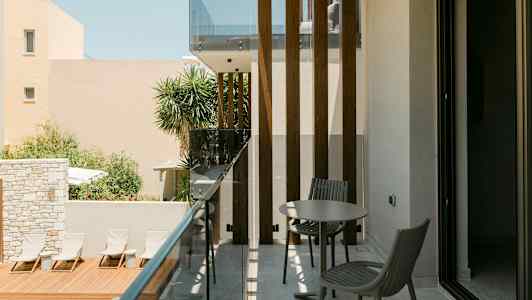 Parveke, jossa kalusteita, lähellä uima-allasta ja aurinkotuoleja. (Tekoälyn luoma teksti)