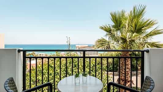 Parveke, jolta on näkymä merelle ja vihreisiin puihin. (Tekoälyn luoma teksti)