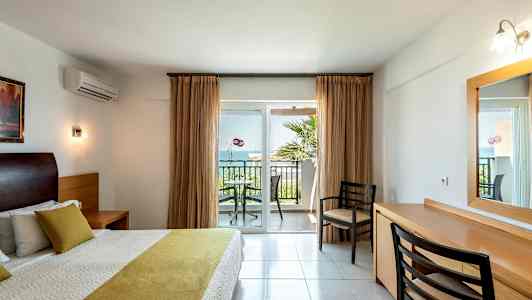 Makuuhuone, jossa parivuode ja näkymä parvekkeelle, jossa on tuoleja ja pöytä. (Tekoälyn luoma teksti)