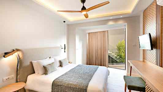 Moderni makuuhuone, jossa on suuri sänky, työpöytä ja televisio. (Tekoälyn luoma teksti)