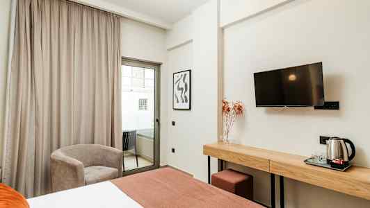 Hotellihuone, jossa sänky, työpöytä, tuoli ja parveke. (Tekoälyn luoma teksti)