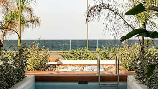 Pieni uima-allas viereisellä puutarha-alueella, näkymä merelle ja lasikaide. (Tekoälyn luoma teksti)