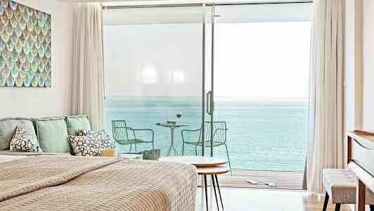 Makuuhuone, josta avautuu merinäkymä suurten lasiovien kautta, jotka johtavat parvekkeelle. (Tekoälyn luoma teksti)