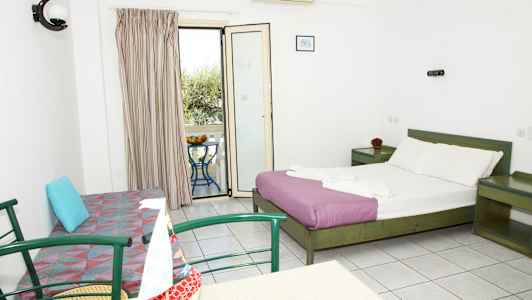 Hotellihuone, jossa on parisänky, sohva, pöytä tuoleineen ja parveke näkymällä. (Tekoälyn luoma teksti)