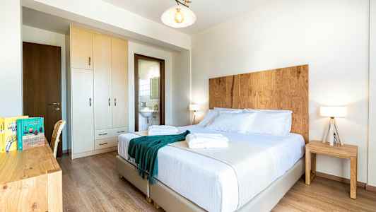 Valkoinen hotellihuone parivuoteella, puukoristeilla ja siisti. (Tekoälyn luoma teksti)