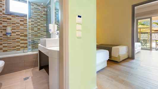 Näkymä kylpyhuoneeseen, jossa on laattaseinät, ja viereiseen makuuhuoneeseen, jossa on vuoteet. (Tekoälyn luoma teksti)