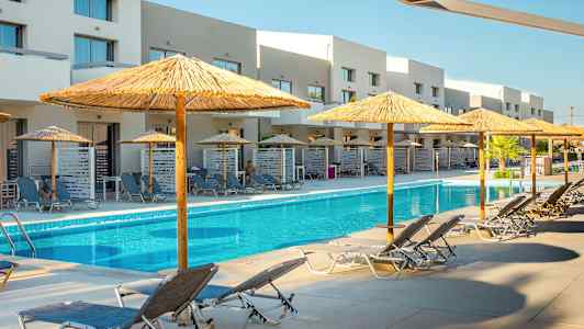 Ulkouima-allas, jossa aurinkotuoleja ja aurinkovarjoja sekä rakennuksia taustalla. (Tekoälyn luoma teksti)