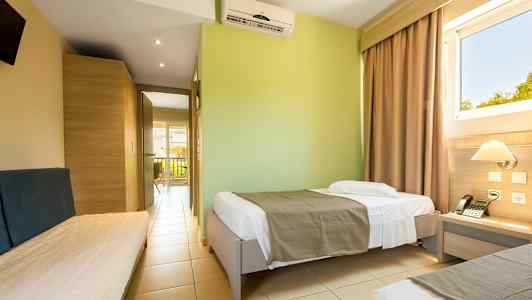 Hotellihuone, jossa on yhden hengen vuoteet ja näkymä ikkunasta. (Tekoälyn luoma teksti)