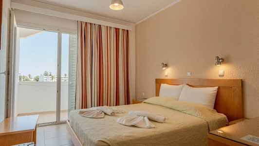 Makuuhuone, jossa on parivuode koristeltuna pyyhkeillä, ja parveke näkymällä. (Tekoälyn luoma teksti)