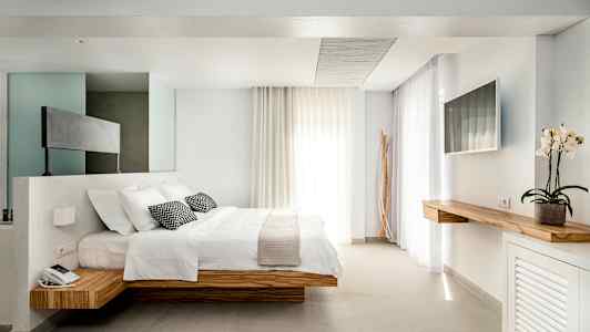 Moderni hotellihuone, jossa on parivuode ja minimalistinen sisustus. (Tekoälyn luoma teksti)