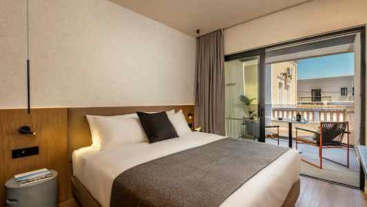 Hotellihuone, jossa parivuode ja parveke istumapaikkoineen. (Tekoälyn luoma teksti)