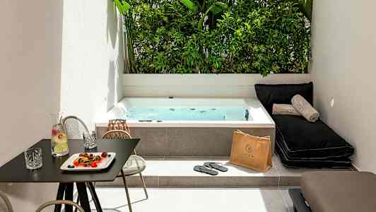 Ulkotila porealtaalla, aurinkotuoleilla ja pöydällä, jolla on juomaa ja välipaloja. (Tekoälyn luoma teksti)