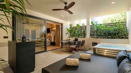 Yksityinen terassi porealtaalla, istuinryhmällä ja aurinkovuoteella. (Tekoälyn luoma teksti)