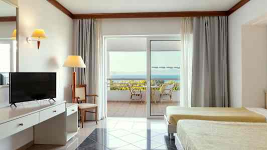 Hotellihuoneen sisätila, jossa kaksi vuodetta, kirjoituspöytä ja terassi näkymällä merelle. (Tekoälyn luoma teksti)