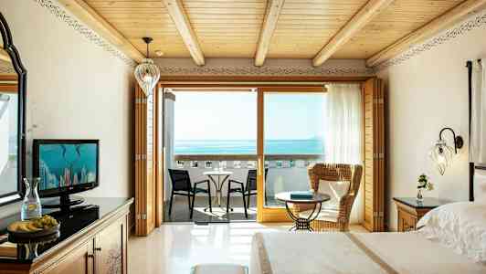 Hotellihuone merinäköalalla, sisältäen parvekkeen istuimilla. (Tekoälyn luoma teksti)