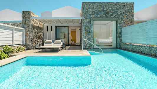 Huvila, jossa uima-allas ja aurinkotuoleja sisäänkäynnin luona. (Tekoälyn luoma teksti)