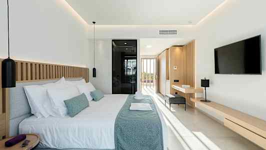 Moderni hotellihuone, jossa parivuode, taustalla ikkuna ja vaaleansävyinen sisustus. (Tekoälyn luoma teksti)