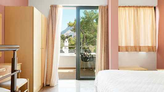 Hotellihuone, jossa ikkuna ja parvekenäkymä. (Tekoälyn luoma teksti)