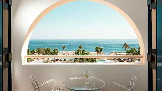 Näköala parvekkeelta, taustalla meri, palmuja ja uima-allas. (Tekoälyn luoma teksti)