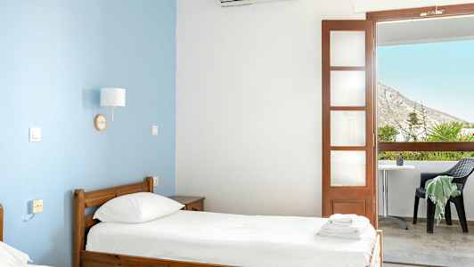 Hotellihuone, jossa on kaksi erillistä vuodetta ja parveke näkymällä. (Tekoälyn luoma teksti)