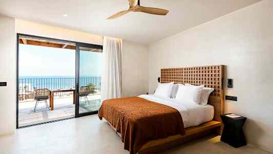 Hotellihuone, jossa parivuode ja uloskäynti parvekkeelle merinäköalalla. (Tekoälyn luoma teksti)