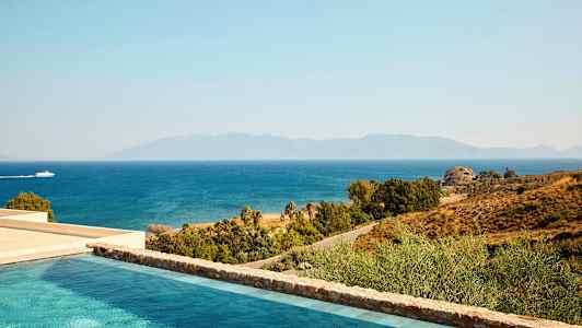 Näkymä uima-altaalle, rannikolle ja merelle, ohikulkeva vene. Taustalla näkyvät vuoret. (Tekoälyn luoma teksti)