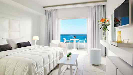 Moderni hotellihuone, jossa parivuode, vaaleat huonekalut ja näkymä merelle. (Tekoälyn luoma teksti)