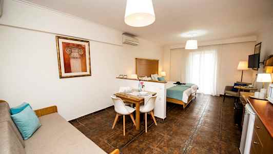 Huone, jossa on sänkypaikka, ruokapöytä ja sohva. (Tekoälyn luoma teksti)