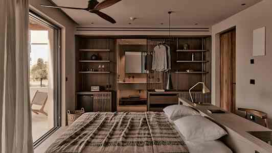 Lämpimästi sisustettu makuuhuone, jossa on parivuode, puuyksityiskohtia ja leveä parvekeovi. (Tekoälyn luoma teksti)