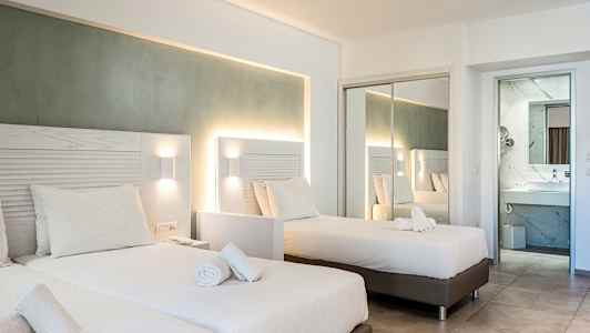 Hotellihuone, jossa on kaksi erillistä vuodetta ja peiliseinä, joka heijastaa huonetta. (Tekoälyn luoma teksti)