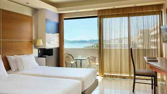 Huone kahdella erillisellä vuoteella, parveke merinäköalalla ja istuimet. (Tekoälyn luoma teksti)