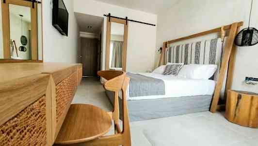 Moderni hotellihuoneen sisustus, jossa on parivuode ja puusisustus. (Tekoälyn luoma teksti)