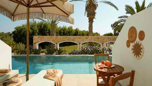 Terassi, jossa uima-allas, aurinkotuoleja ja pöytä tuoreiden hedelmien kanssa. (Tekoälyn luoma teksti)